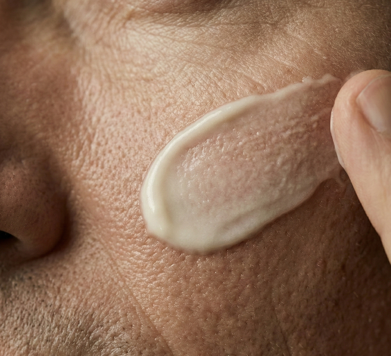 Close-up of a hand applying cream to skin